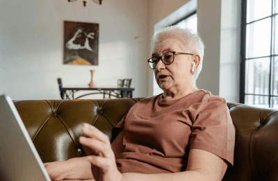 Woman Sitting on a Couch Using a Laptop