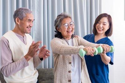Elderly woman exercising with a nurse's help